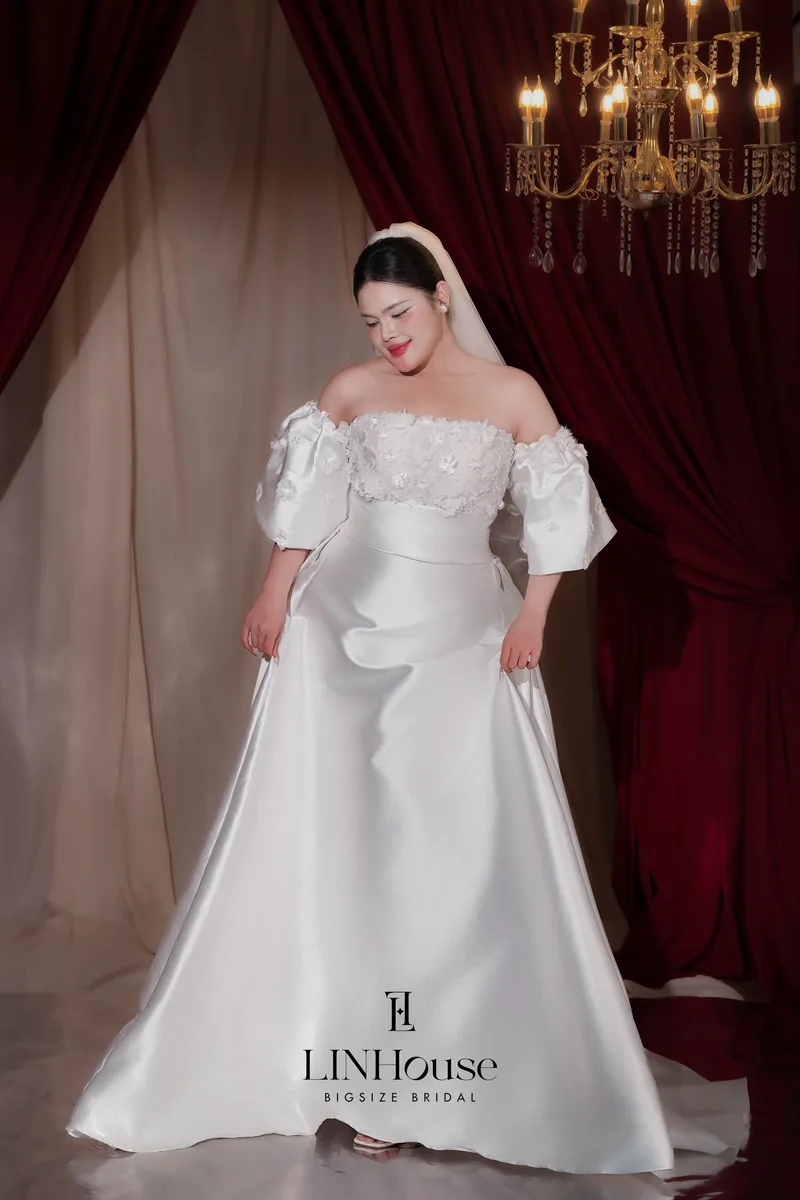 SCENE explores the many ways a bride can express herself on her wedding day — with every dress creating a different mood, moment and presence.  The collection moves between romantic lace, timeless satin and luminous glitter, from soft refined silhouettes to dramatic ball gowns designed especially for plus size and big size brides.  Rather than defining the bride through one aesthetic, SCENE celebrates her freedom to be romantic, minimal, radiant or bold — while always remaining unmistakably herself.  Every dress, a different scene. Every scene, still you.